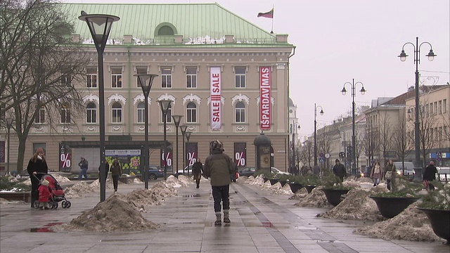 Siauliai的居民走过一个广场，广场上积满了雪。高清。视频下载