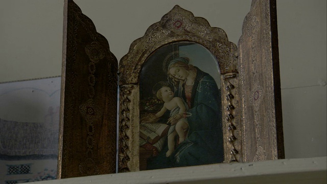 在一个和尚的房间里，一个华丽的画框围绕着一幅小小的宗教画。高清。视频下载