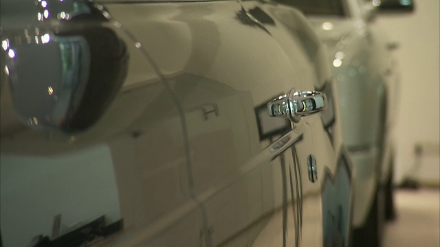 一辆豪华车在经销商的抛光表面上反映了陈列室。视频素材
