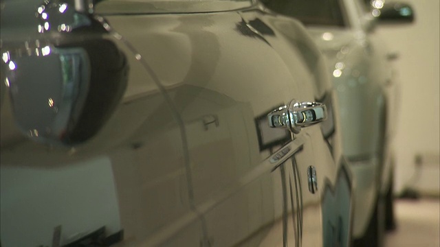 一辆豪华轿车光滑、抛光的车门反映了它所展示的陈列室。视频素材