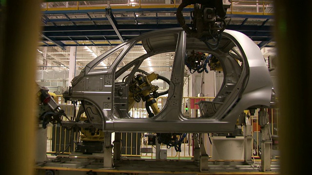 机器人焊接在装配线上的汽车底盘上。在高清视频下载