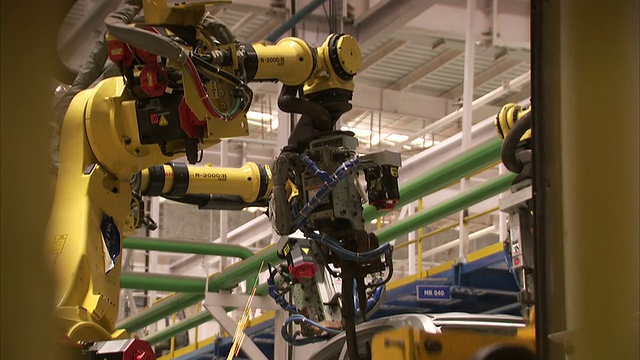 机器人在汽车厂的装配线上组装汽车。在高清视频素材