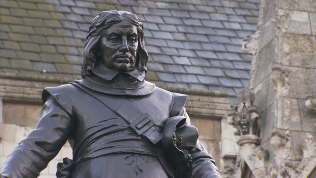 国会大厦外的一座青铜雕像刻画了奥利弗·克伦威尔(Oliver Cromwell)微微低着头的形象。视频下载