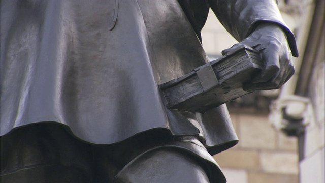 国会大厦外的一座青铜雕像描绘了奥利弗·克伦威尔左手拿着一本圣经的形象。视频下载