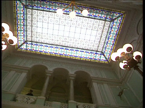 讲台上的列宁雕像缩小到苏联中央银行的主厅，华丽的楼梯和巨大的彩色玻璃天花板下的灯光视频下载