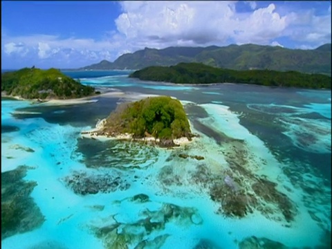 郁郁葱葱的岛屿和热带蓝色的海洋，还有空旷的白色沙滩和珊瑚礁视频下载