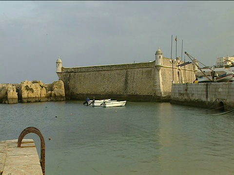 两艘小船停泊在拉各斯港，背景是港墙视频下载