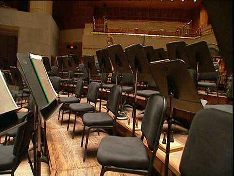 音乐站在倾斜的管弦乐队舞台上，椅子之间的轨道向前视频下载