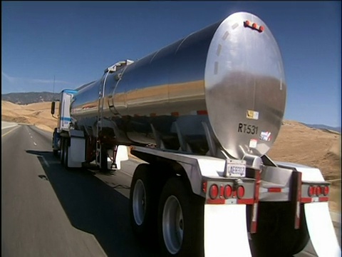 铬油罐车沿着笔直开放的沙漠道路行驶视频下载