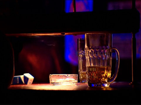 迪斯科舞厅闪烁的灯光下的啤酒杯和烟灰缸视频下载