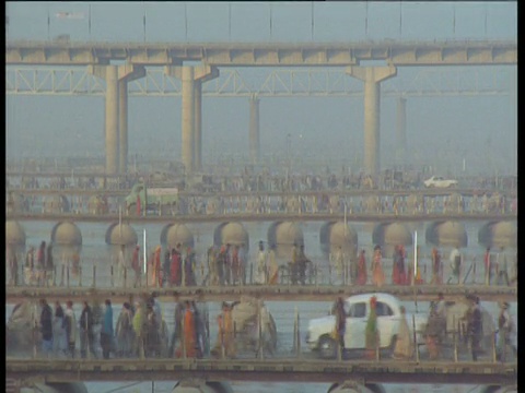 印度阿拉哈巴德大壶节期间，人们和汽车在朦胧的恒河上穿梭于许多桥梁上视频素材