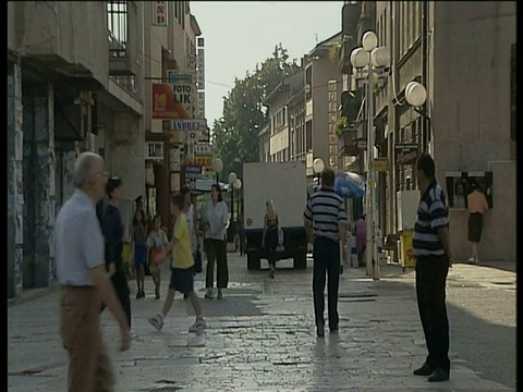 在塞尔维亚巴尼亚卢卡购物区，人们走在铺着鹅卵石的街道上视频素材
