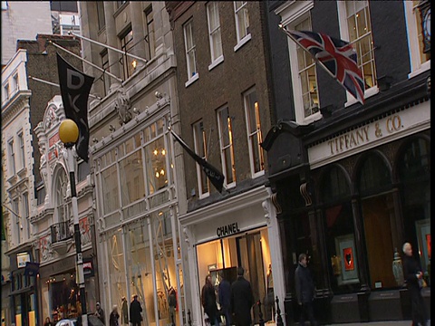 购物者和黑色出租车在街道上的设计师商店伦敦视频素材