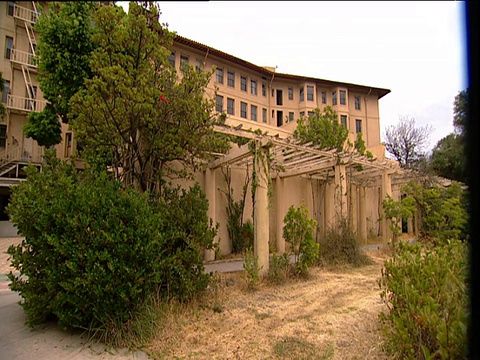 潘穿过破旧的大使饭店和杂草丛生的花园离开了好莱坞视频素材