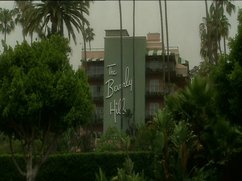 比佛利山庄酒店的标志旁边的酒店建筑周围郁郁葱葱的花园好莱坞视频素材