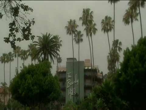 放大到贝弗利山庄酒店的标志旁边的建筑周围的郁郁葱葱的花园好莱坞视频素材