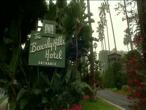 放大到比佛利山庄酒店入口标志周围的郁郁葱葱的花园酒店在好莱坞的背景视频素材
