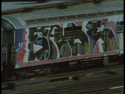 从被涂鸦覆盖的地铁列车沿着高架铁路行驶视频下载