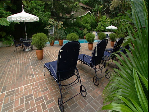 太阳躺椅和游泳池周围郁郁葱葱的花园地区Chateau Marmont日落大道洛杉矶视频素材