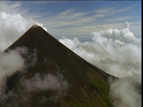 在新不列颠，巴布亚新几内亚，巨大的陡峭的火山耸立在云和森林之上视频下载