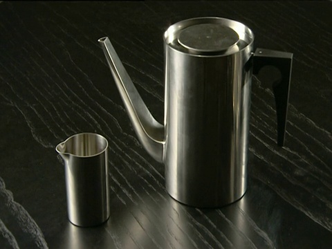 黑色木桌上摆放着现代镀铬咖啡壶和奶壶视频素材