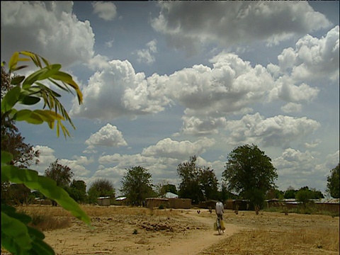 坦桑尼亚多多马地区，人们在尘土飞扬的道路上骑车视频下载