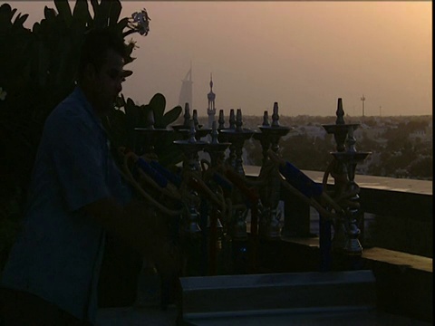 服务员在迪拜的酒店屋顶上堆叠水烟管视频下载