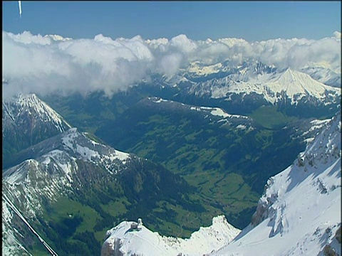 云覆盖的山峰下，蓝天和郁郁葱葱的山谷瑞士阿尔卑斯山视频下载