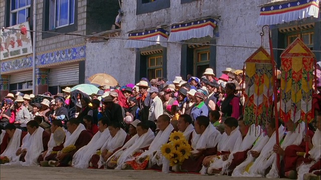佛教僧侣坐在成排的观众在游行视频素材