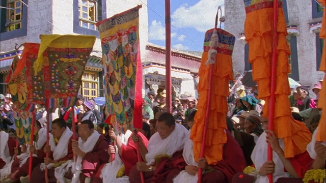 潘正对着一排手持经幡的僧侣。视频素材
