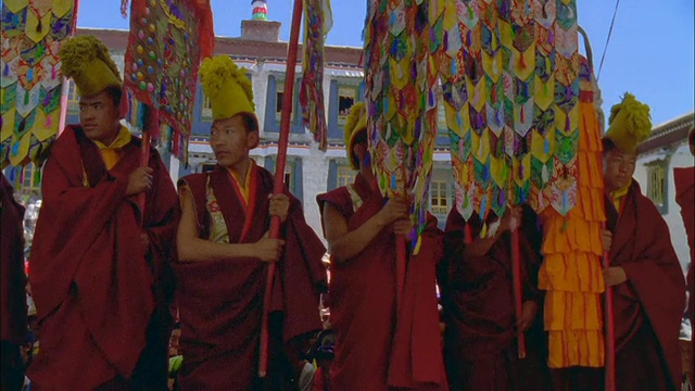 佛教僧侣站在队列中举着经幡在游行视频素材