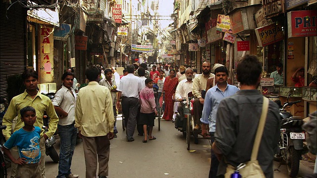 行人和购物者穿过新德里一个繁忙的市场。高清。视频素材