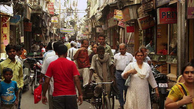 行人和购物者在新德里一条繁忙的街道上行走。高清。视频素材