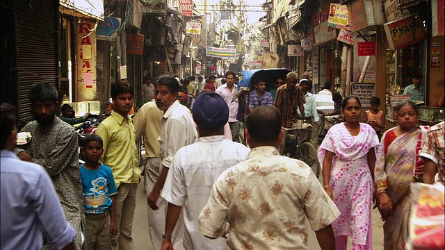 行人和购物者在新德里一条繁忙的街道上行走。高清。视频素材