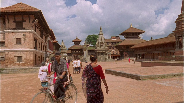 穿着纱丽的妇女走过广场，宝塔建筑和寺庙的背景，巴克塔普尔，尼泊尔。视频素材