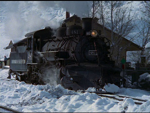 从白雪覆盖的山上倾斜下来，蒸汽火车沿着轨道缓慢移动，杜兰戈视频素材