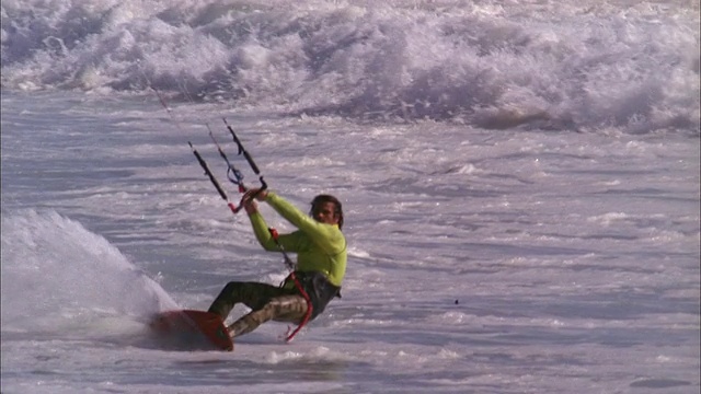 风筝冲浪者被举起来执行半空中扭转，然后下降回到水。视频素材