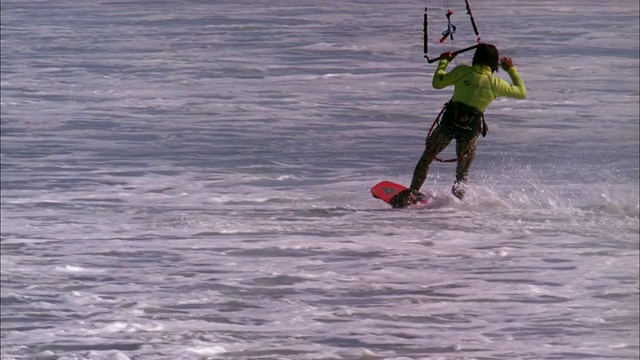 风筝冲浪者在水面上着陆前在半空中表演特技高清版。视频素材