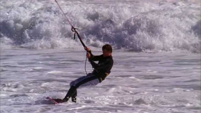风筝冲浪者被举起到空中，翻转和回到水面上。视频下载