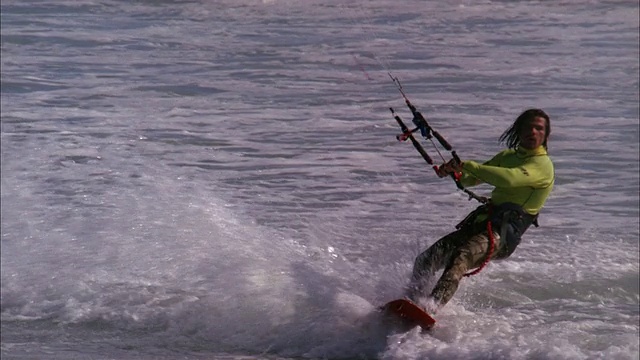 风筝冲浪者举起到空中，翻转板与一只手之前降落在水与水花可用的高清。视频下载