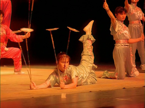 中国，女马戏团演员在棍子上平衡旋转的盘子视频下载