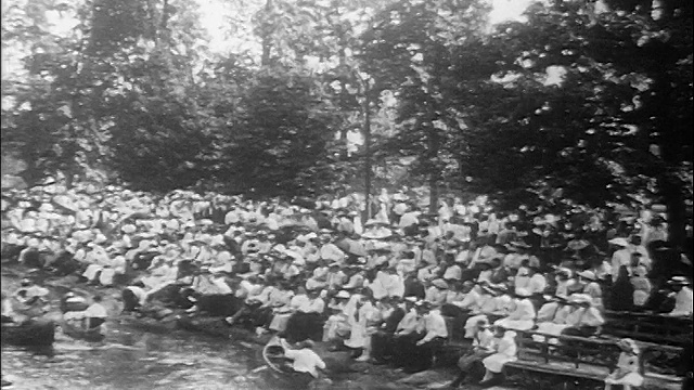 20世纪10年代的高角度PAN人群聚集在底特律附近的湖岸，观看人们乘坐独木舟视频下载