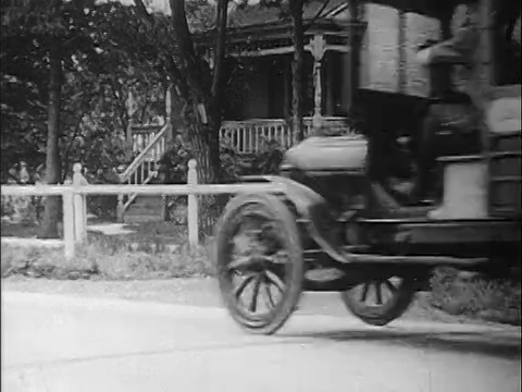 1910年代的邮车停在屋前，有个男人带着包裹/纪录片等着视频素材