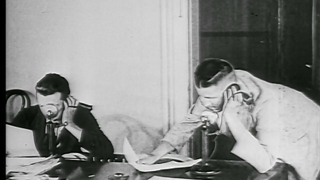 1927年，两个拿着报纸的男人跑进房间，抓起电话，开始交谈(报纸记者?)视频素材