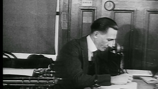 1927年，打字机旁的男人接电话+开始在纸上写字(报社记者?)视频素材