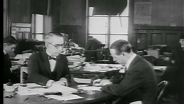 1927年，两个人坐在桌子旁/一个抽烟/一个在纸上写字(报社?)视频素材