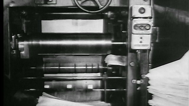 1927年的B/W将从印刷机出来的报纸倾斜成堆栈/人们抓住它们/新闻胶片视频下载