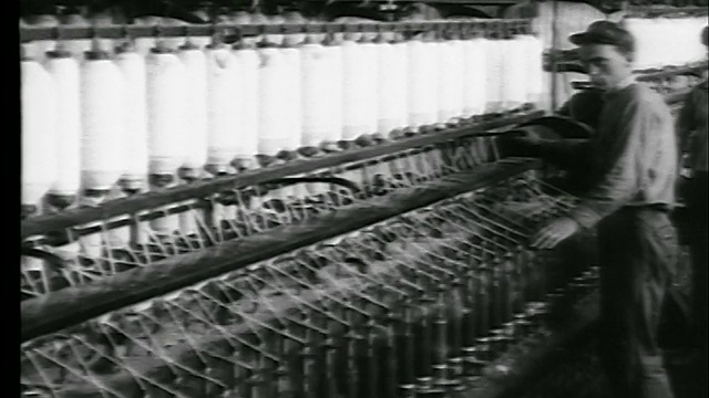 1922年，在棉纺厂/新闻卷筒中，人们用棉线调整纺纱筒子上的机器视频素材