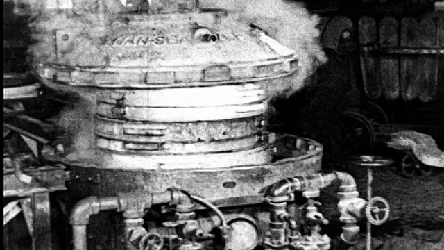 1925年，固特尔轮胎厂，一名男子从蒸汽轮胎模具机上取下盖视频素材