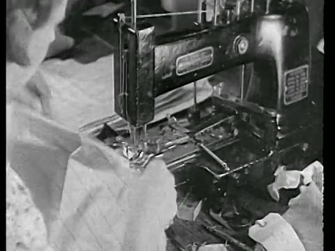 20世纪20年代，一名妇女在服装厂的缝纫机上缝制纽扣视频素材